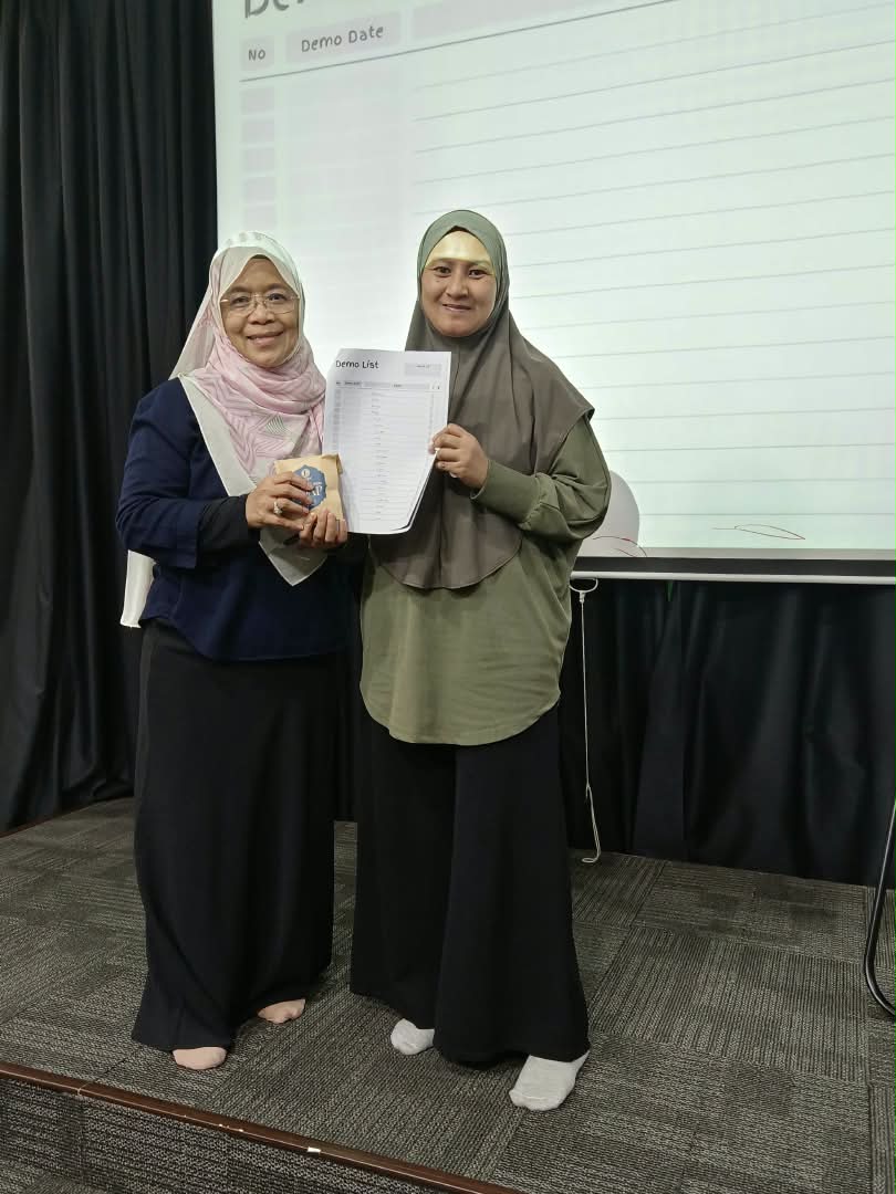 Coach Ida presenting a demo list achievement to a team member