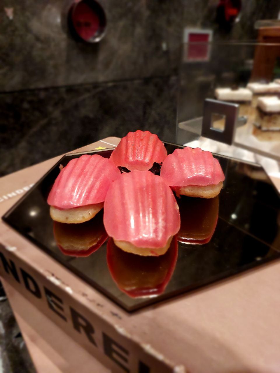 Elegant pink madeleine desserts on a mirrored tray