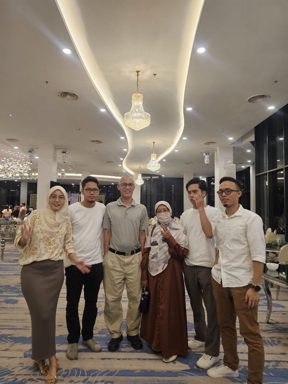 Family together in a grand ballroom with chandeliers